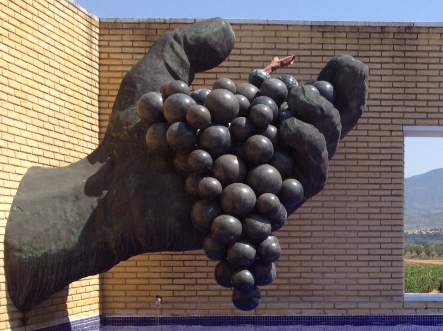 Escultura de Cándido Pazos sobre una mano gigante que sostiene un racimo de uvas. Ubicado en el Museo del Vino de Vivanco.