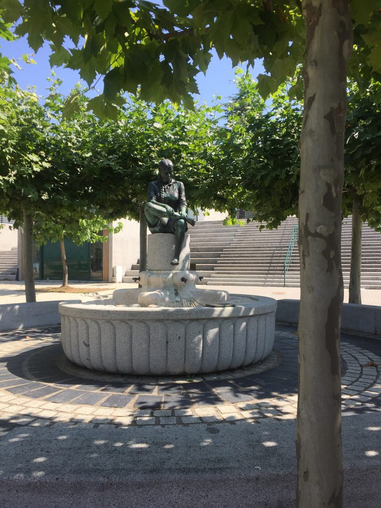 Escultura de Cándido Pazos sobre una peregrina sentada en una fuente.